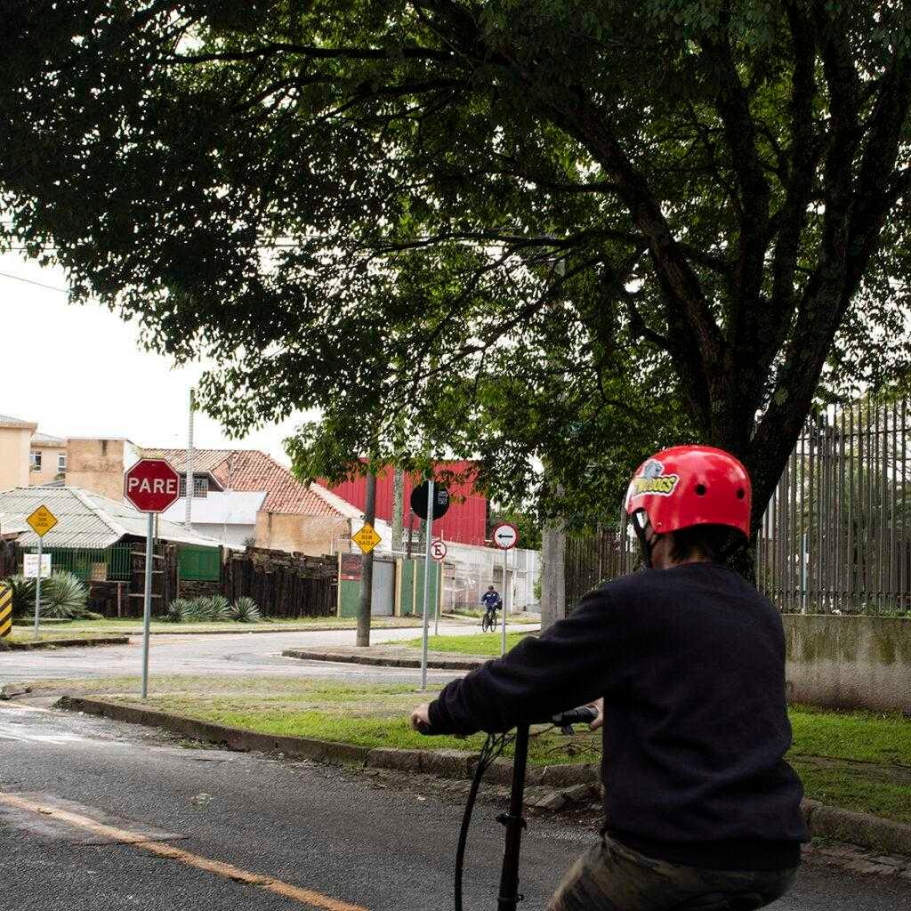 Ciclista de capacete parada em cima de uma bicicleta.