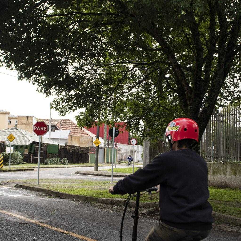 Ciclista de capacete parada em cima de uma bicicleta.