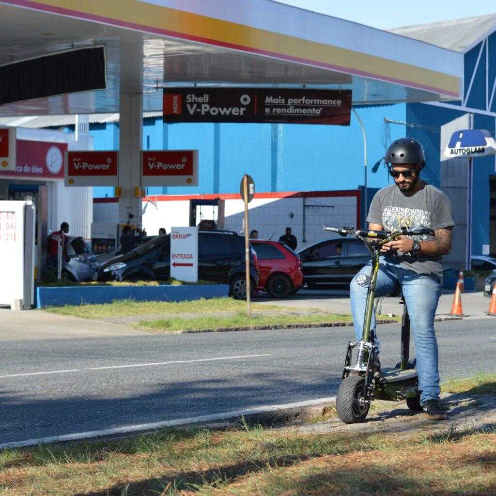 Patinete parado em frente a post de gasolina lotado.