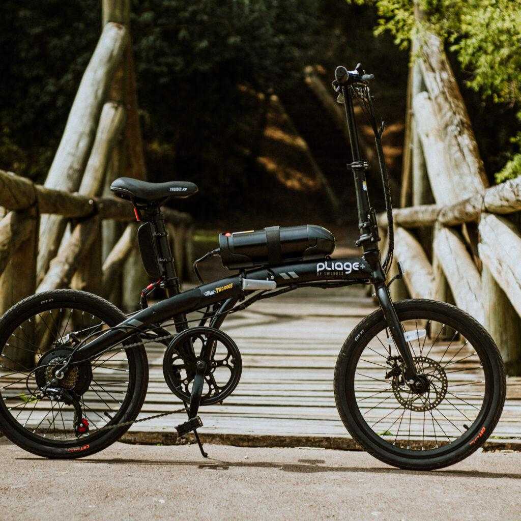 Bicicleta elétrica em frente a ponte de madeira no parque.