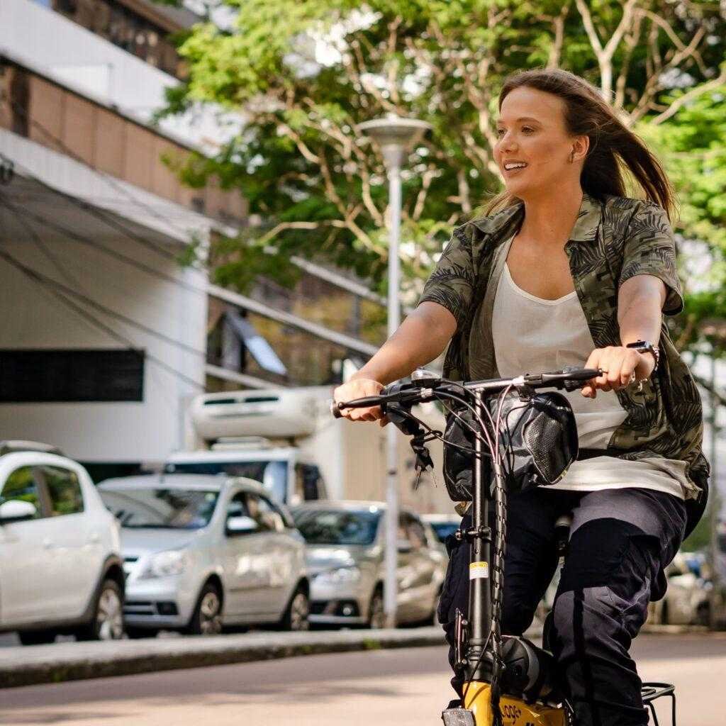 Mulher andando com uma  bicicleta da Two Dogs em uma rua durante o dia.