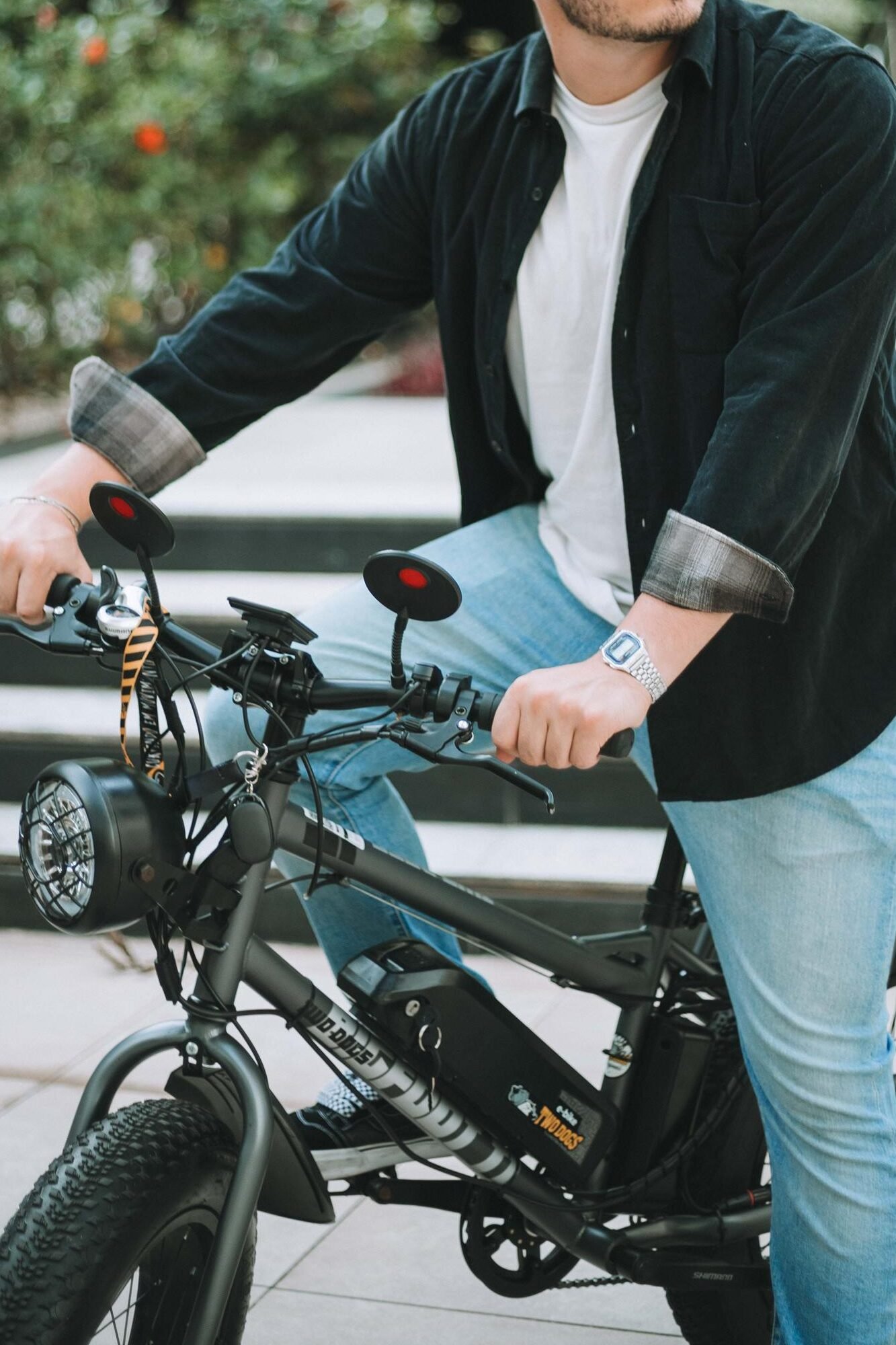Pessoa sentada em uma bicicleta elétrica, com as mãos apoiadas no guidão.