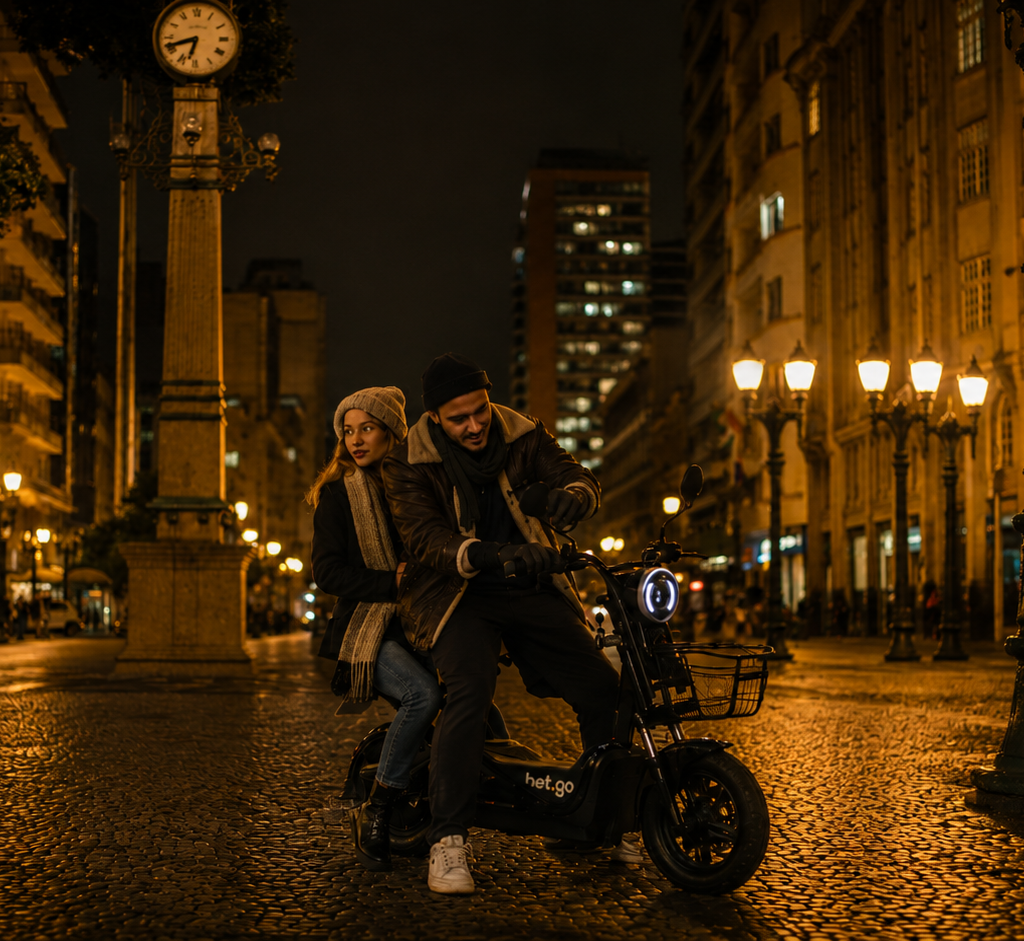 Bicicleta Elétrica no Inverno: Guia Completo Para Pedalar no Frio com Segurança 1 Casal passeando de bicicleta elétrica no inverno pelas ruas de Curitiba durante a noite, usando roupas de frio enquanto percorre o centro histórico iluminado, destacando a mobilidade urbana com conforto e estilo.
